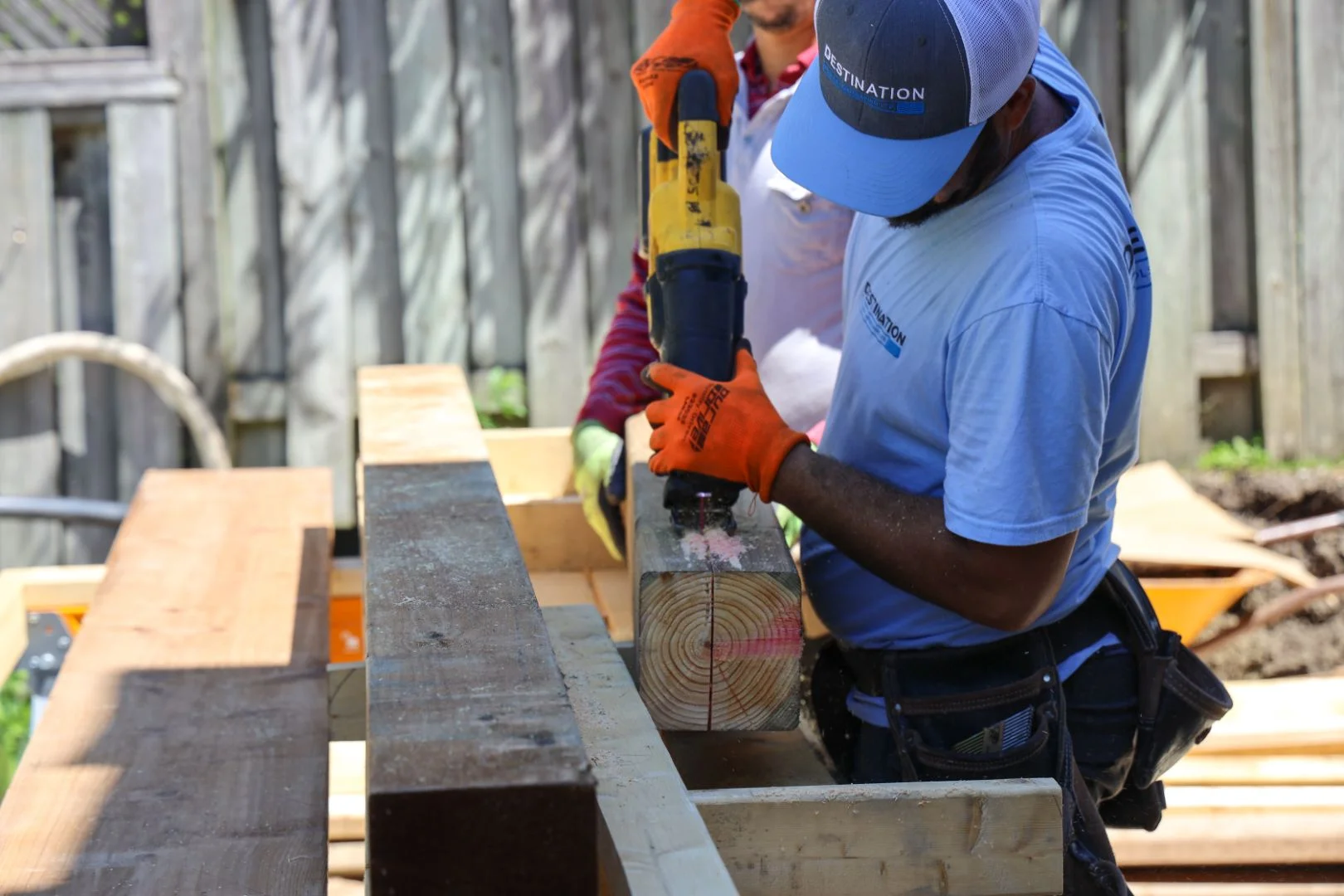 Destination Pools workers drilling and cutting timber beams for pergola or deck framing