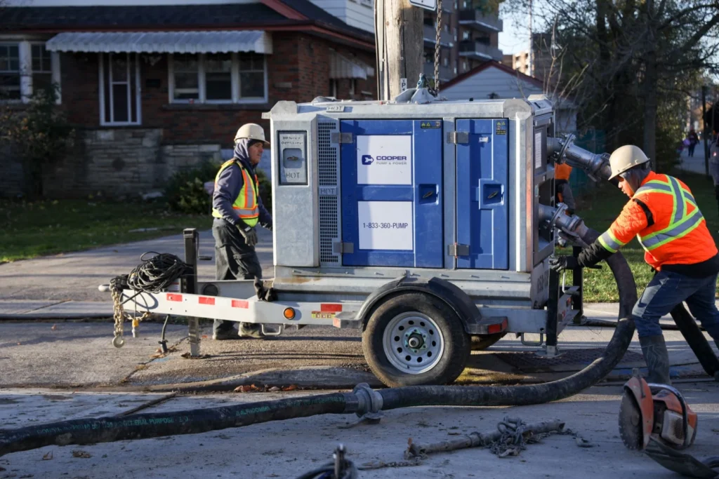 Gio Contracting Inc. sewer and watermain construction crew with heavy equipment on city street excavation